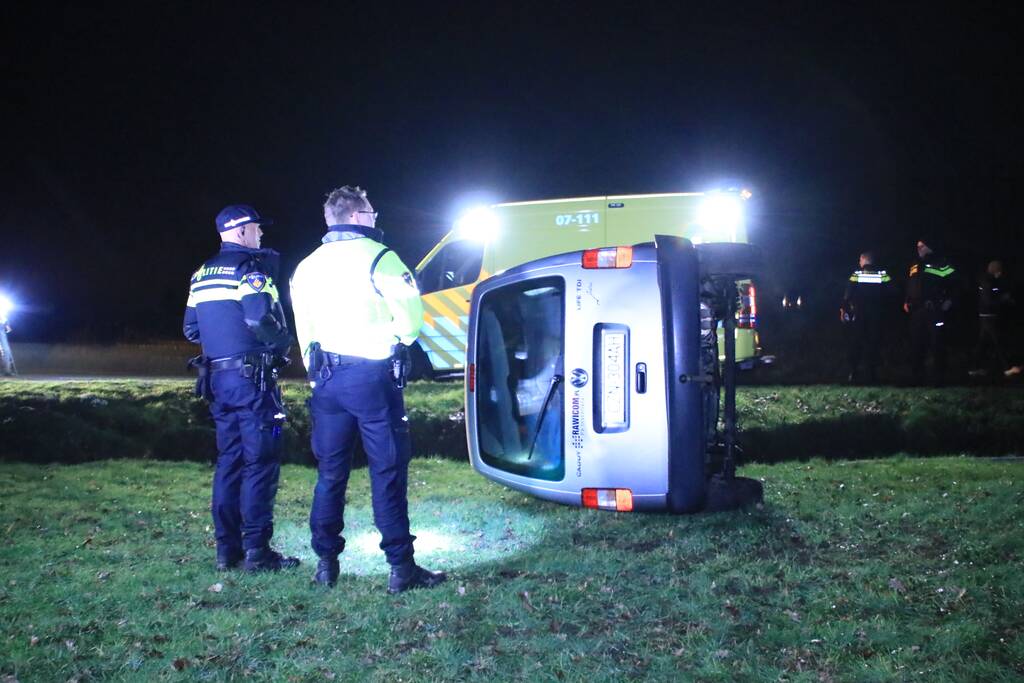Bestelbus vliegt uit de bocht en belandt op zijkant, twee aanhoudingen
