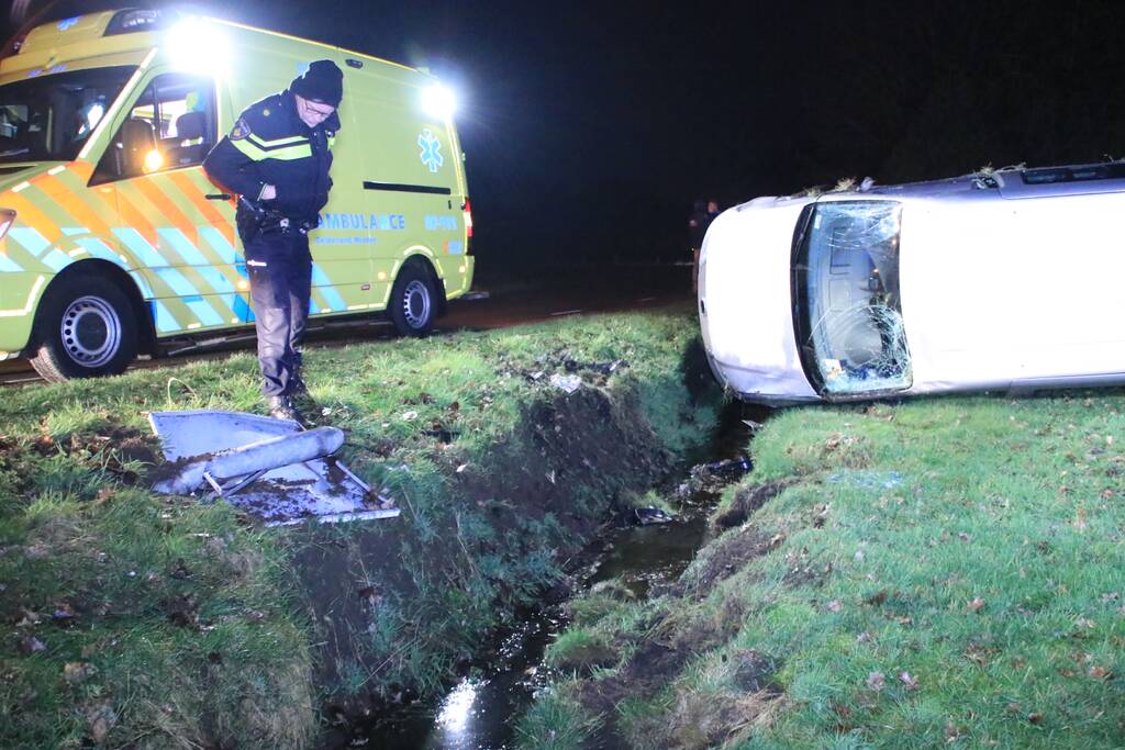 Bestelbus vliegt uit de bocht en belandt op zijkant, twee aanhoudingen