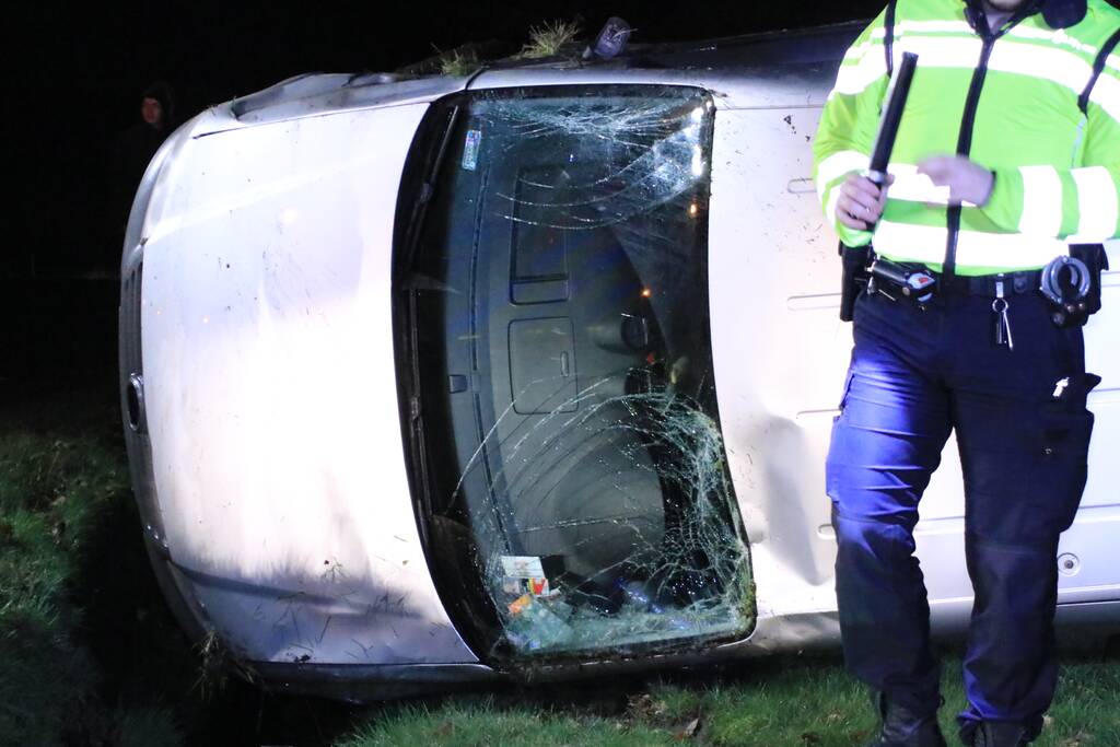 Bestelbus vliegt uit de bocht en belandt op zijkant, twee aanhoudingen