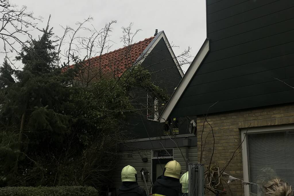 Boom drijgt op schuur te vallen