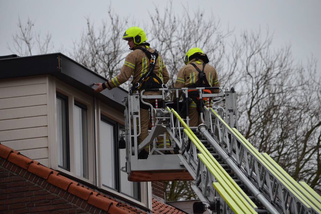 Brandweer zet dakrand vweer vast