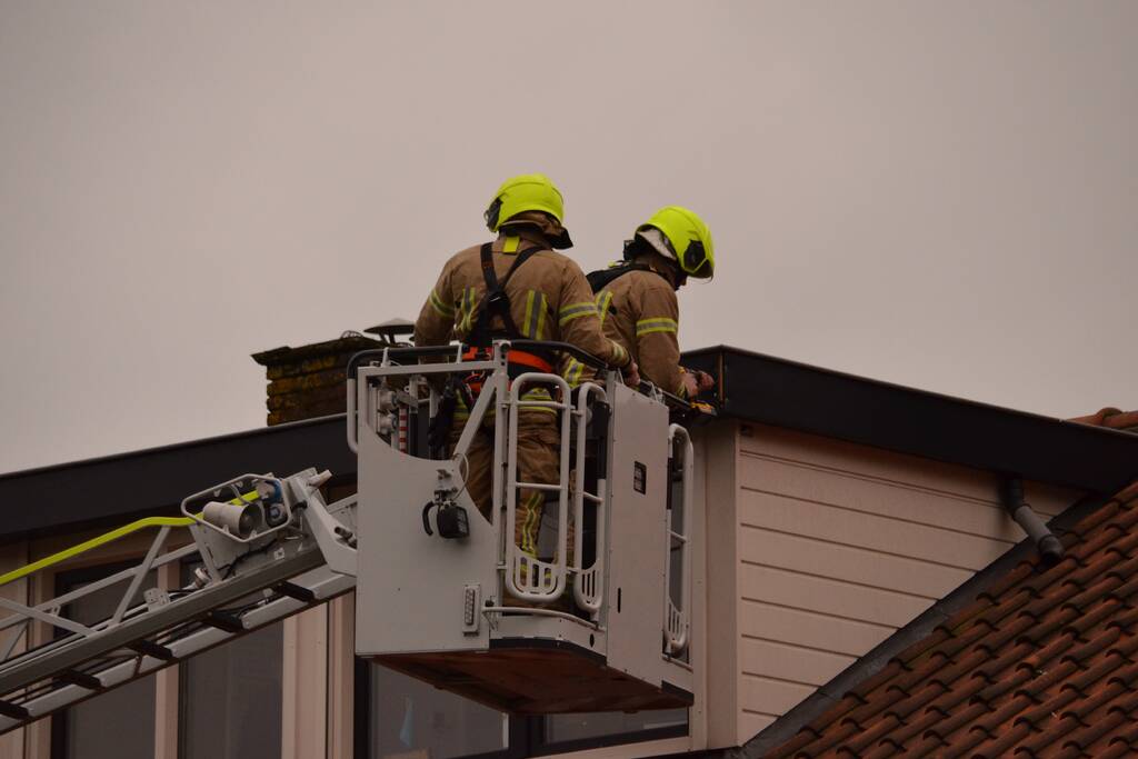 Brandweer zet dakrand vweer vast