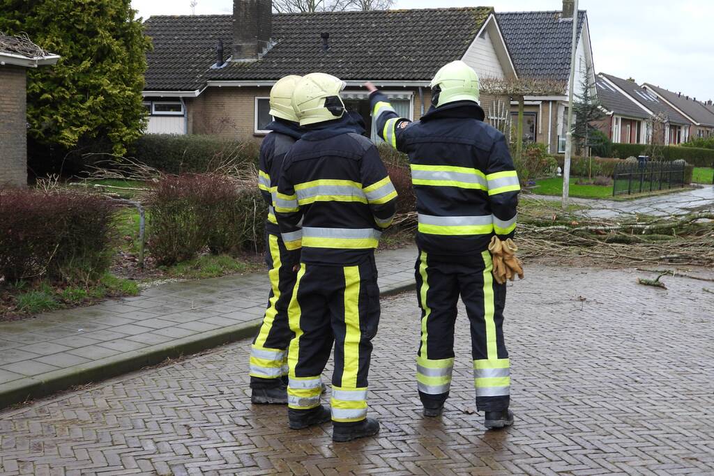 Boom breekt af en valt op woning