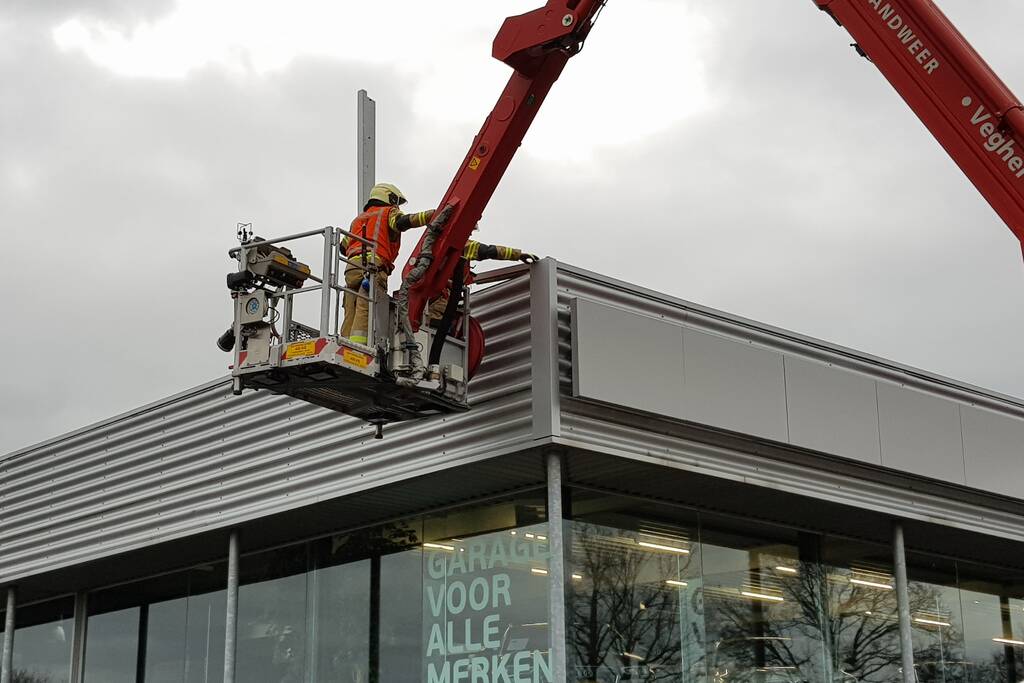 Gevelplaten van autoberijf losgewaaid