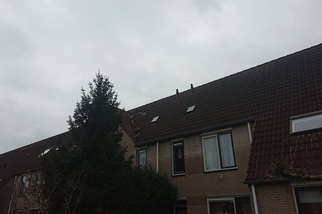 Dakpannen vliegen van woning