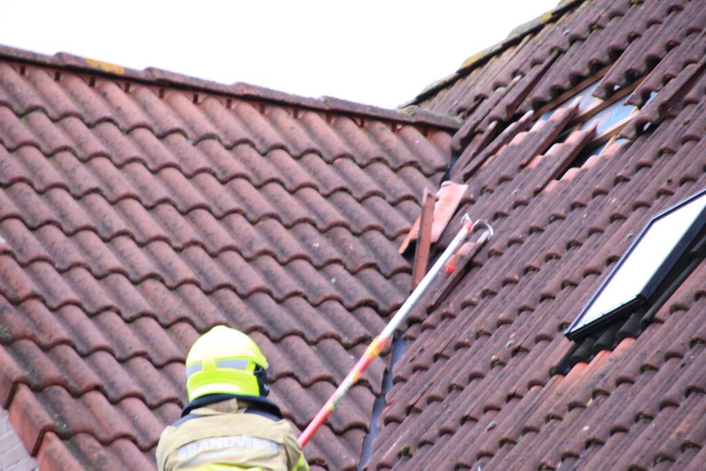 Dakpannen vliegen van woning