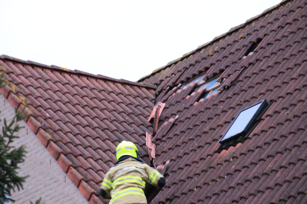 Dakpannen vliegen van woning