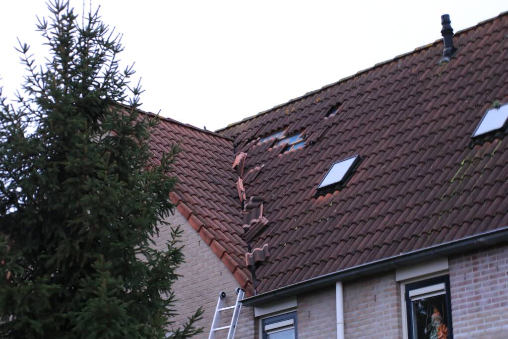 Dakpannen vliegen van woning