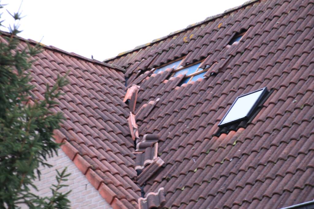 Dakpannen vliegen van woning