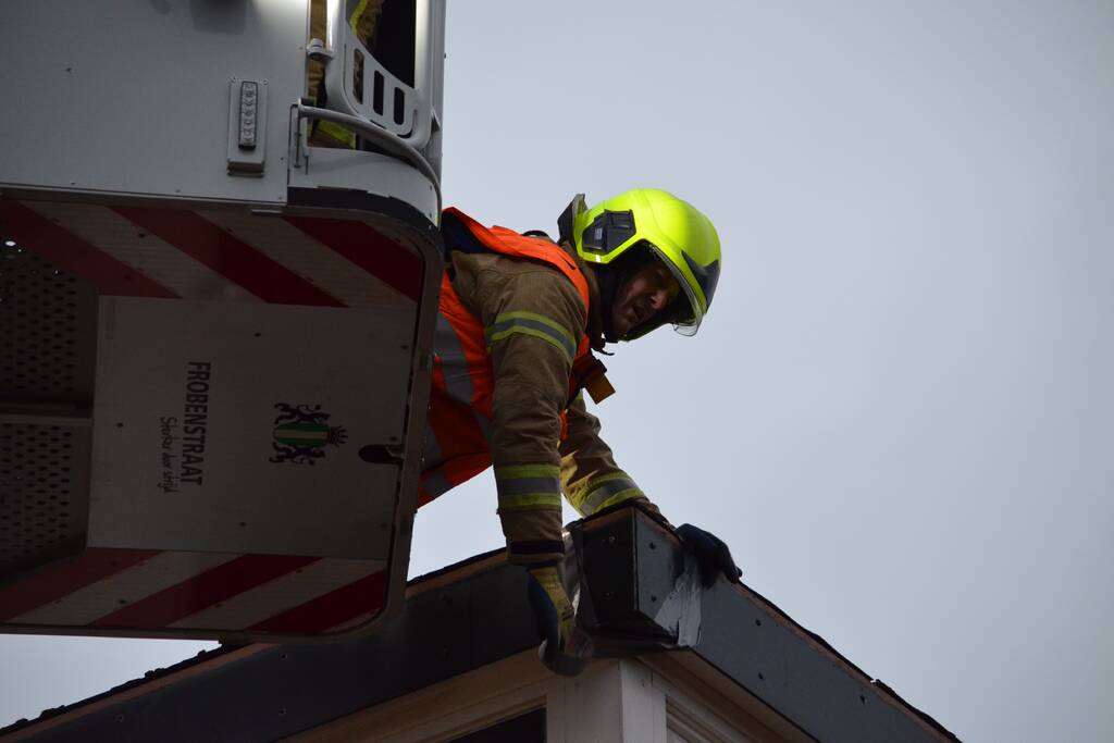 Brandweer maakt losgelaten dak vast