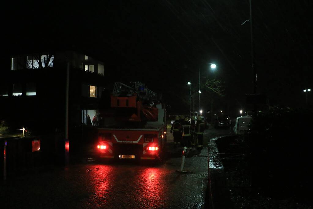 Brandweer druk met losse dakdelen op bedrijfspand