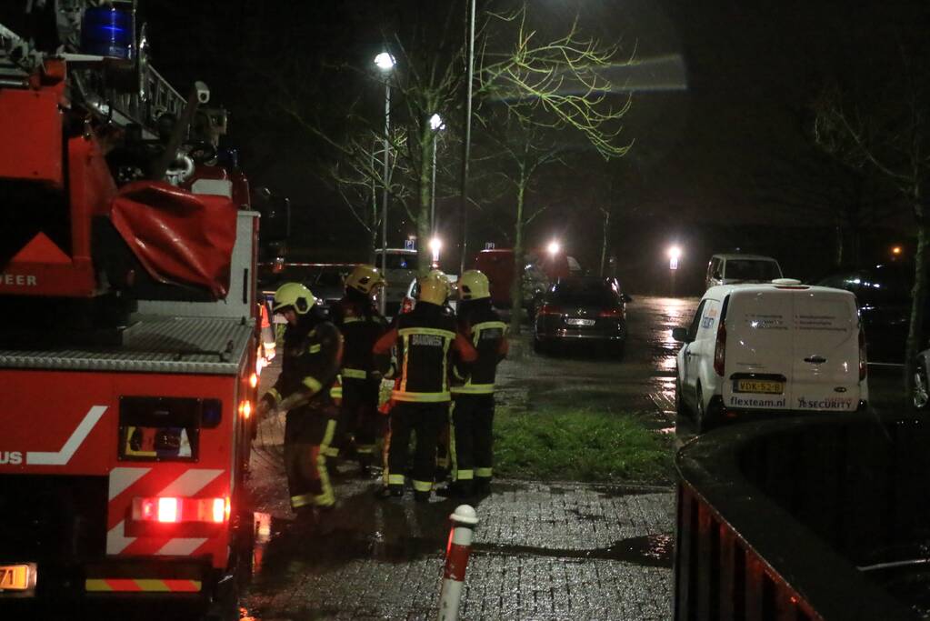 Brandweer druk met losse dakdelen op bedrijfspand
