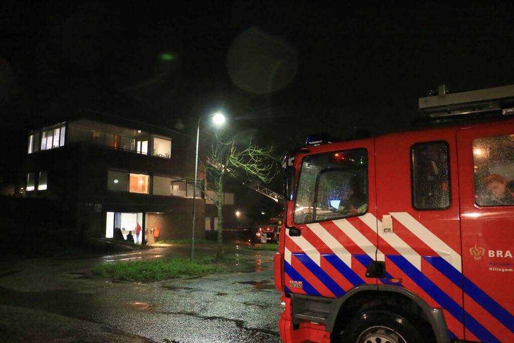 Brandweer druk met losse dakdelen op bedrijfspand