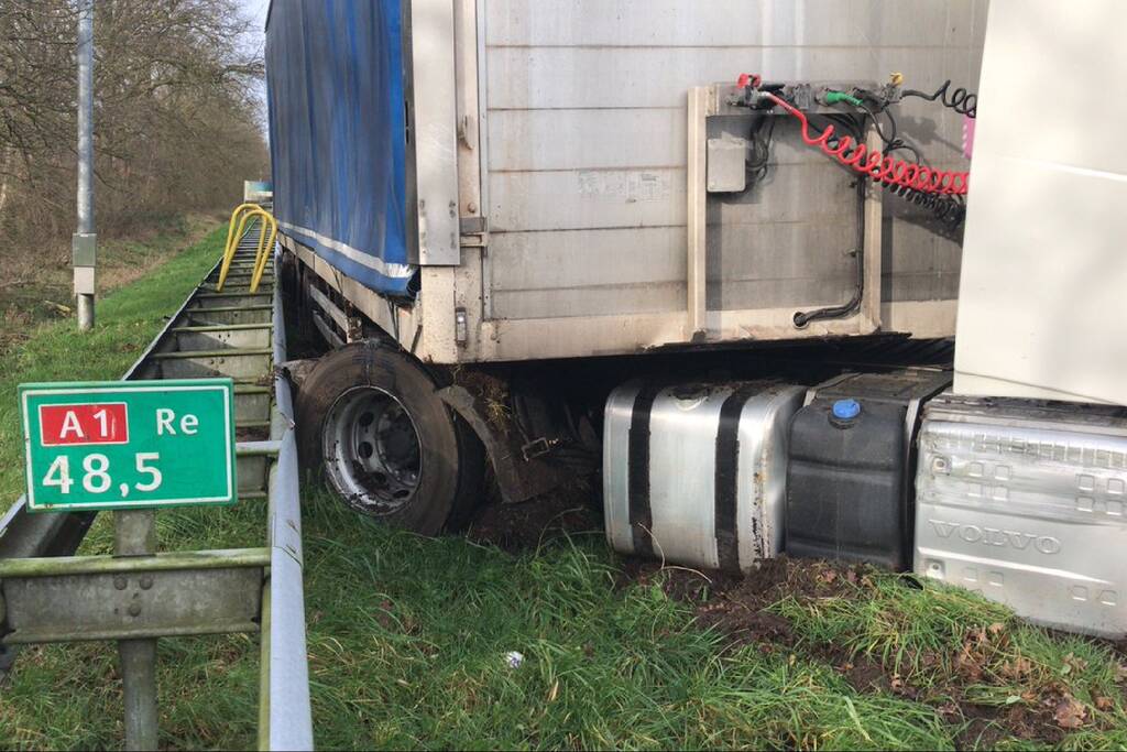 Vrachtwagen belandt in berm tegen vangrail