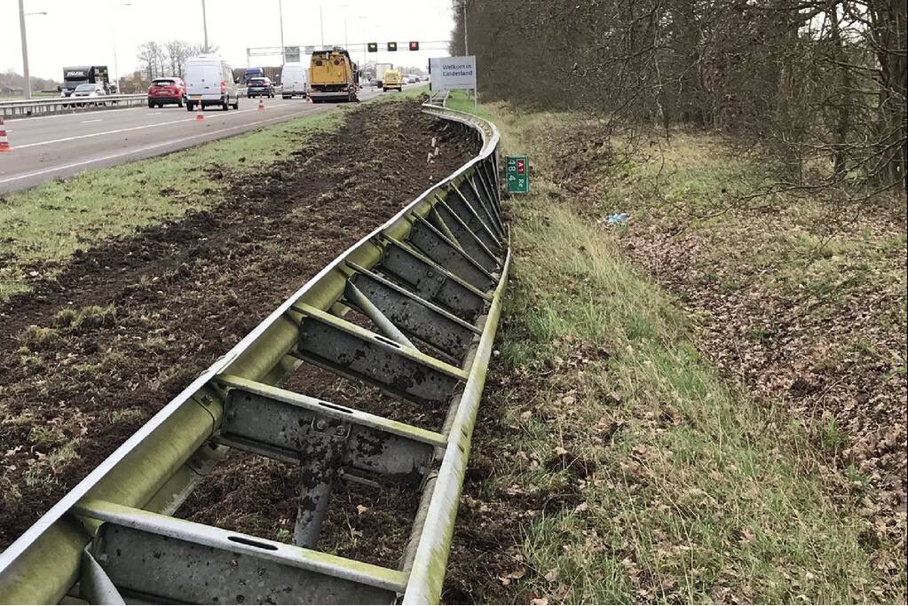 Vrachtwagen belandt in berm tegen vangrail