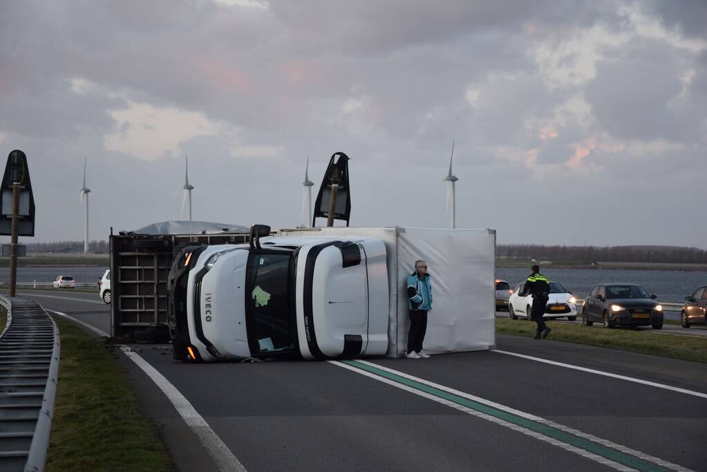 Lege vrachtwagen gekanteld door harde wind op Philipsdam