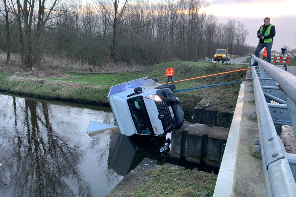 Bestelbus raakt van de weg en belandt te water