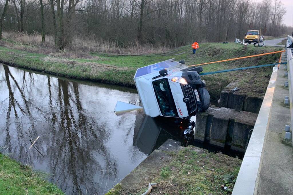 Bestelbus raakt van de weg en belandt te water