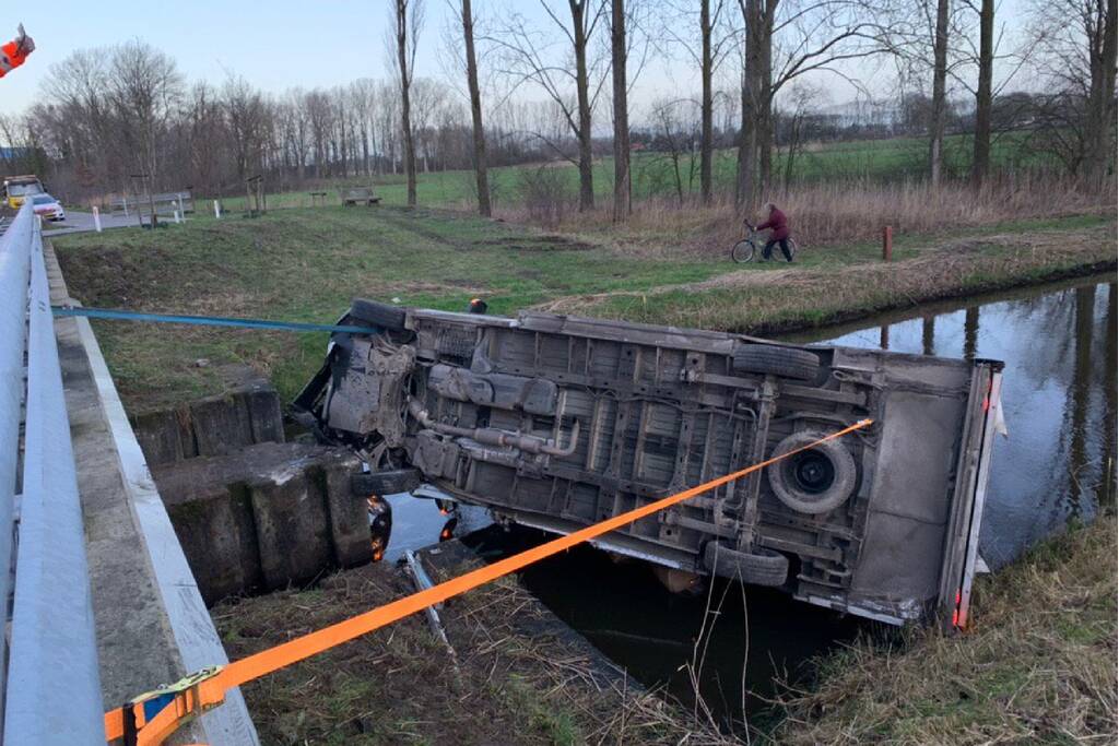 Bestelbus raakt van de weg en belandt te water