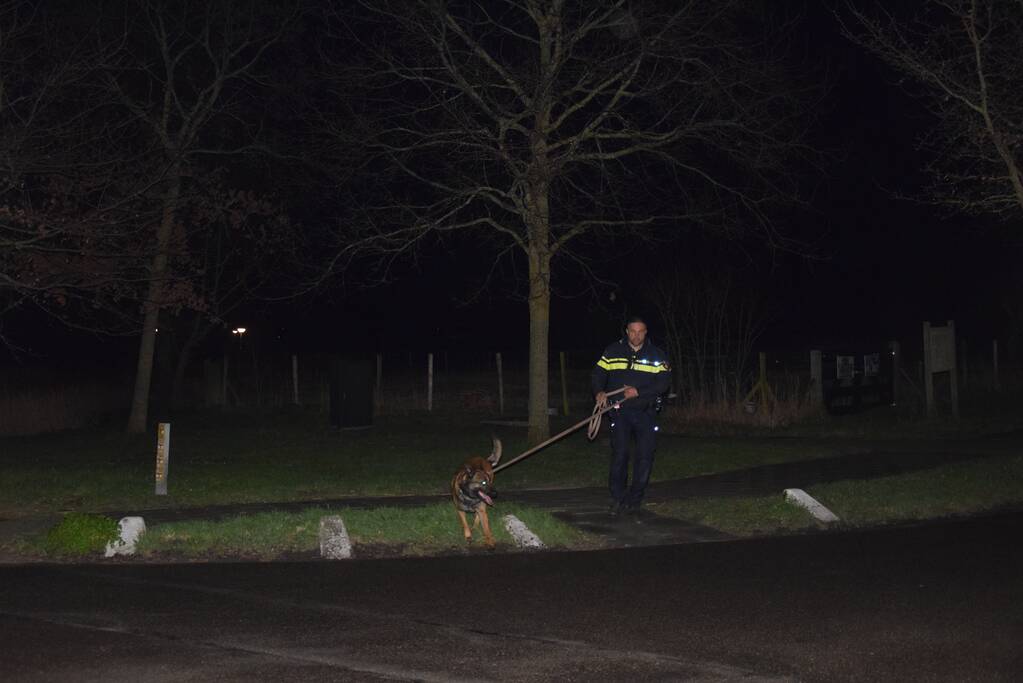 Politieauto en personenauto beschadigd door stenen op rijbaan