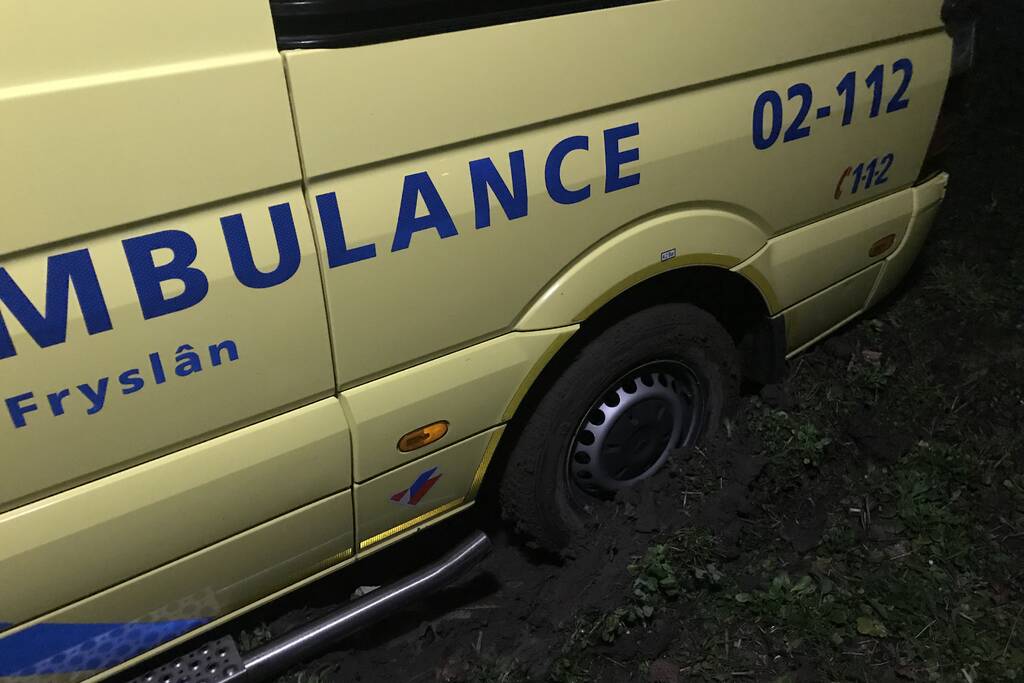 Ambulance komt vast te zitten in grasveld