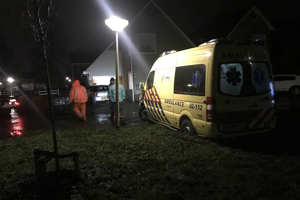Ambulance komt vast te zitten in grasveld