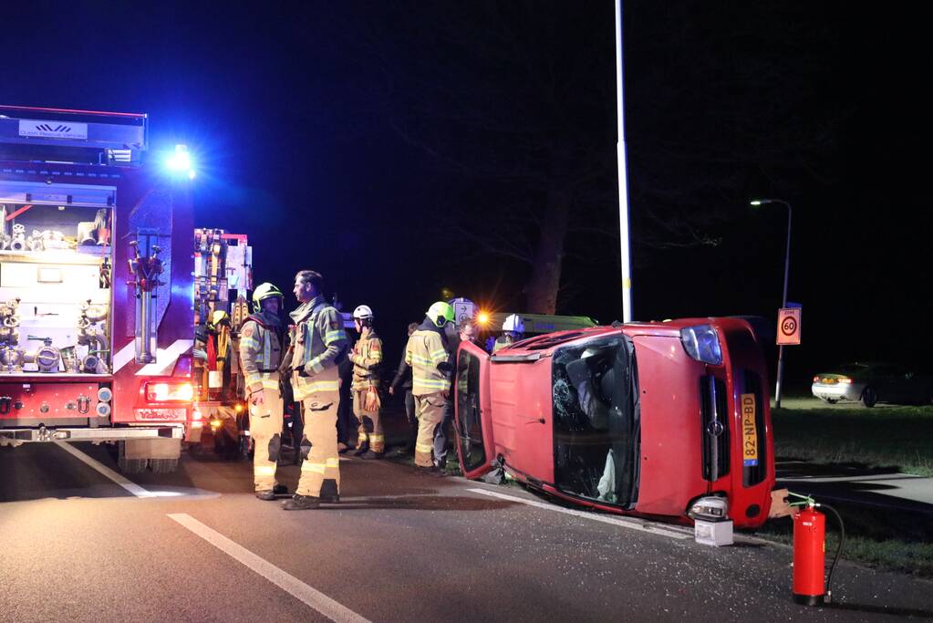 Auto op zijn kant na botsing tegen lantarenpaal