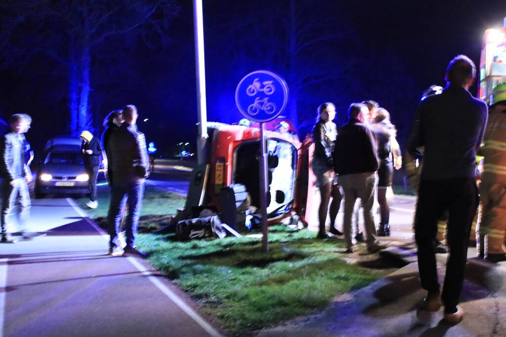 Auto op zijn kant na botsing tegen lantarenpaal