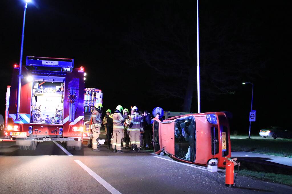 Auto op zijn kant na botsing tegen lantarenpaal