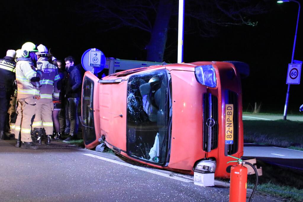 Auto op zijn kant na botsing tegen lantarenpaal