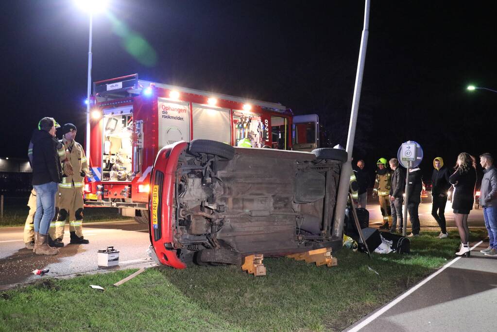 Auto op zijn kant na botsing tegen lantarenpaal