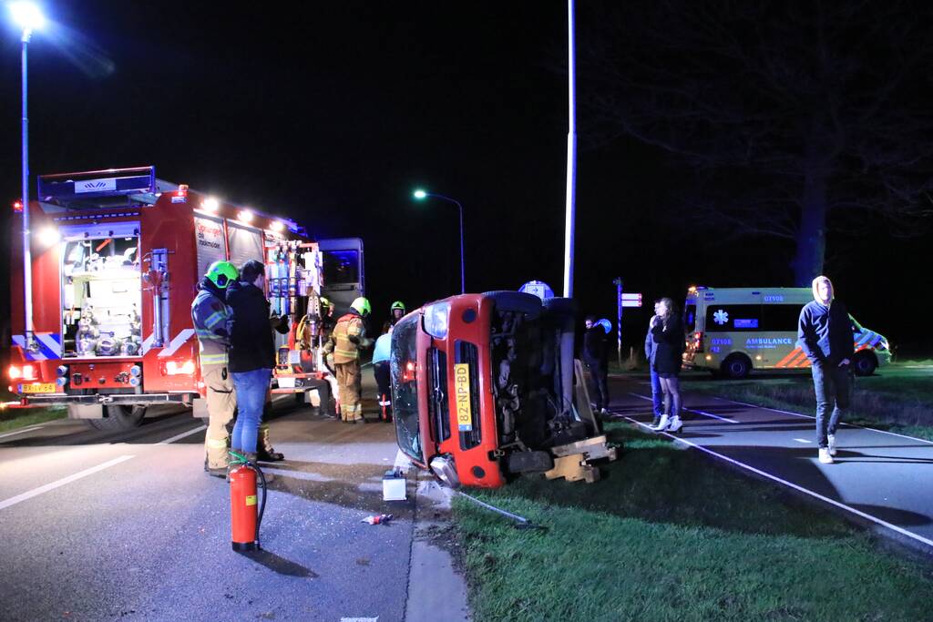 Auto op zijn kant na botsing tegen lantarenpaal