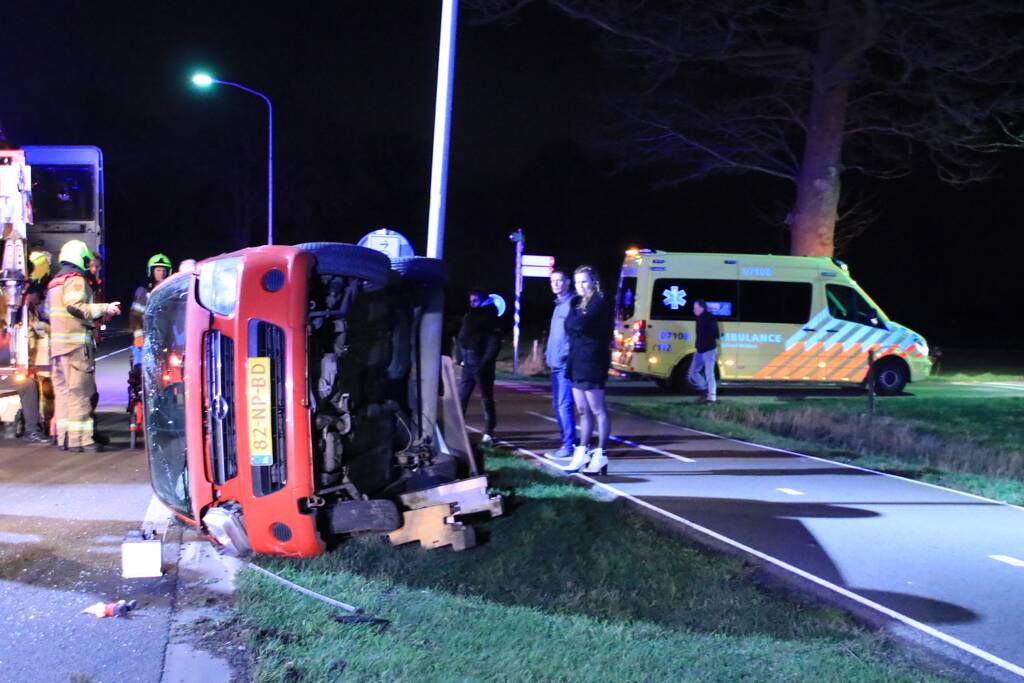 Auto op zijn kant na botsing tegen lantarenpaal