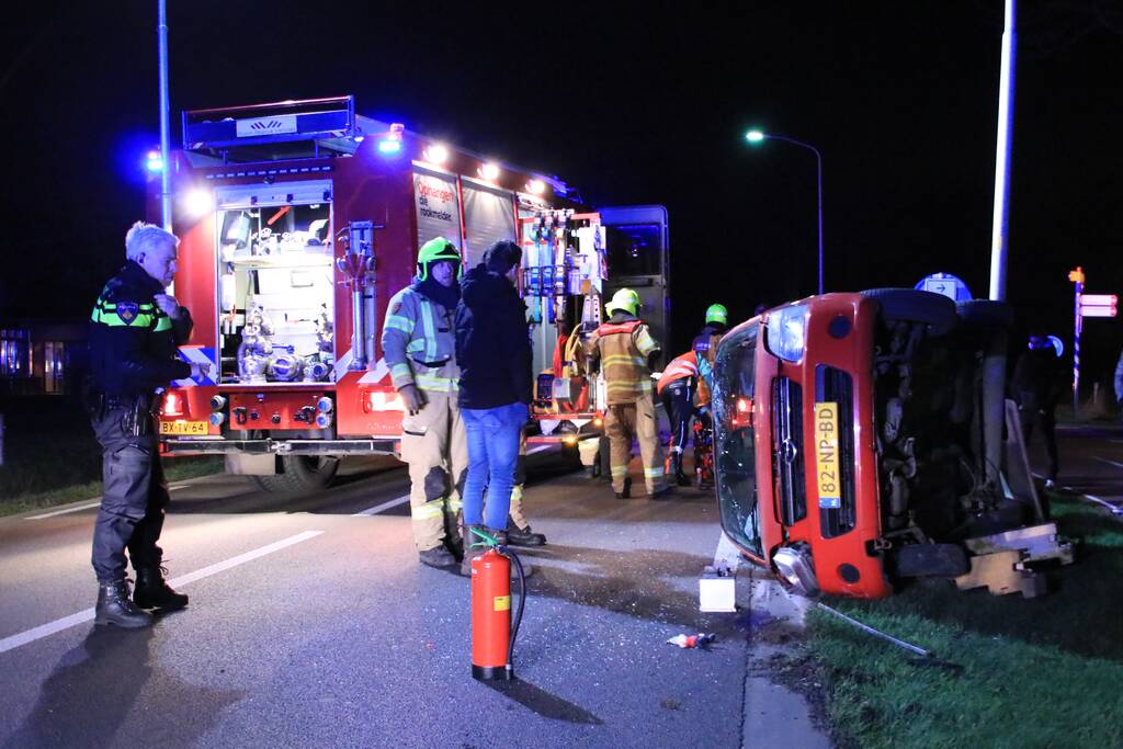 Auto op zijn kant na botsing tegen lantarenpaal