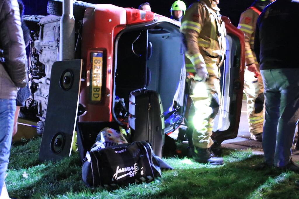 Auto op zijn kant na botsing tegen lantarenpaal