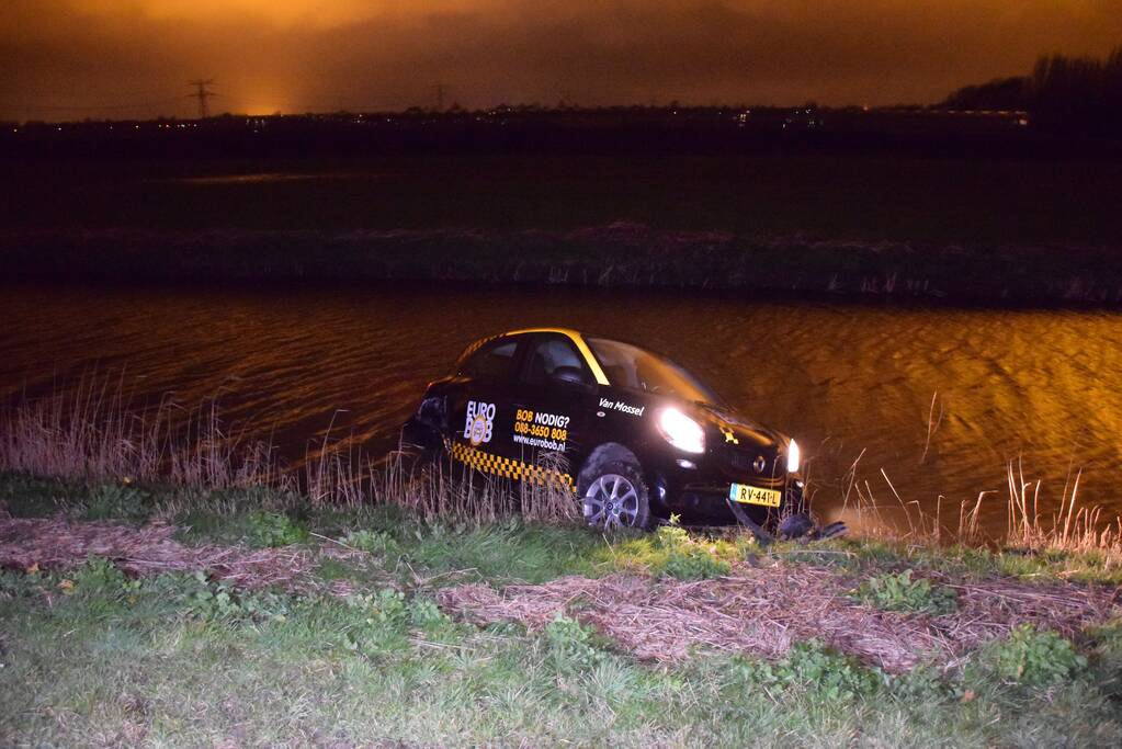 Auto belandt in sloot na botsing met hek
