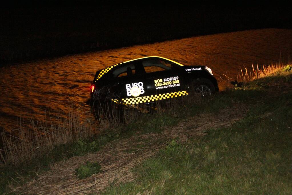 Auto belandt in sloot na botsing met hek