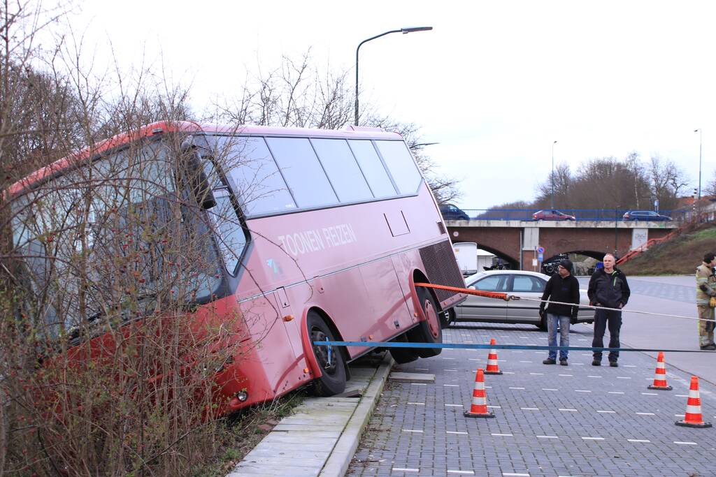Touringcar rijdt talud af