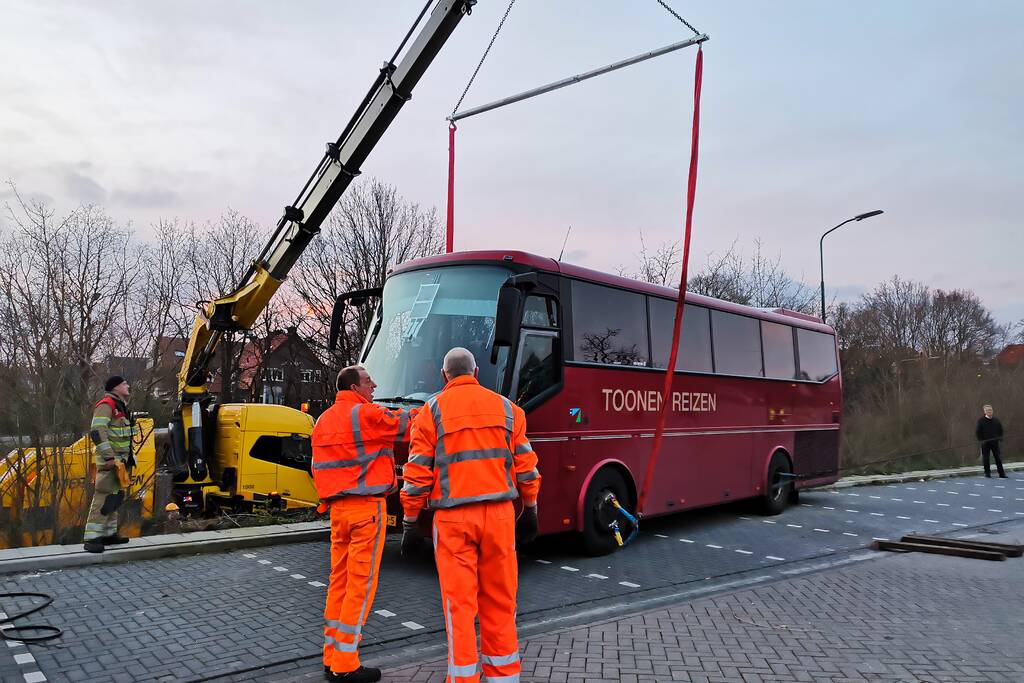 Touringcar rijdt talud af