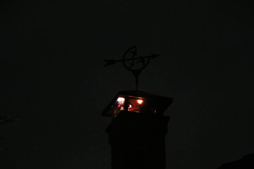 Vlammen slaan uit schoorsteen van woning