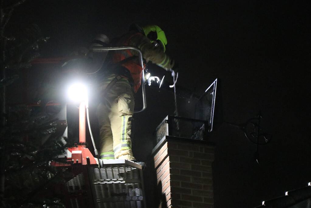 Vlammen slaan uit schoorsteen van woning