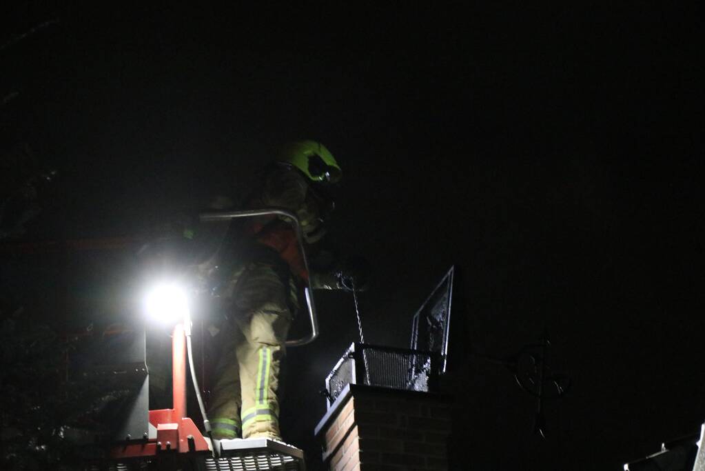 Vlammen slaan uit schoorsteen van woning