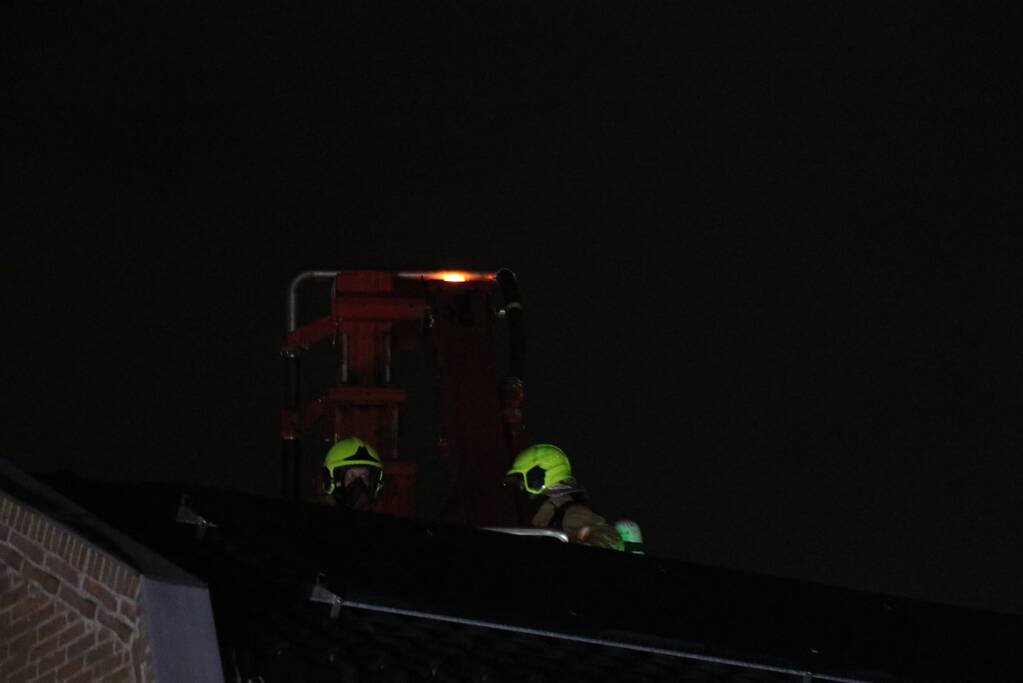 Vlammen slaan uit schoorsteen van woning