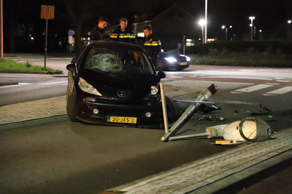 Auto ramt lantaarnpaal op rotonde