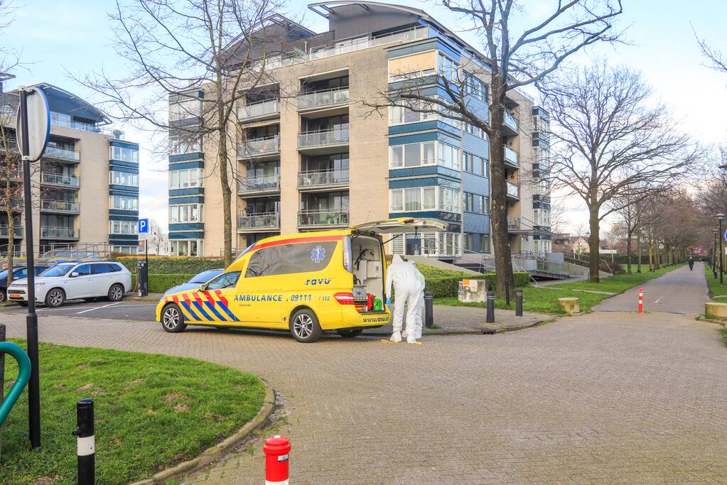 Mannen in witte pakken halen vermoedelijke coronapatiënt uit huis