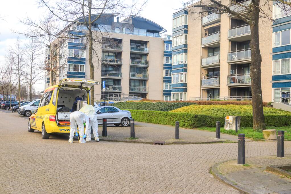 Mannen in witte pakken halen vermoedelijke coronapatiënt uit huis