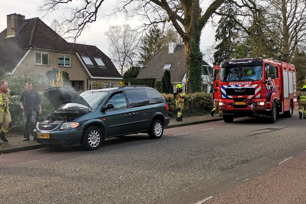 Rook onder de motorkap van de auto