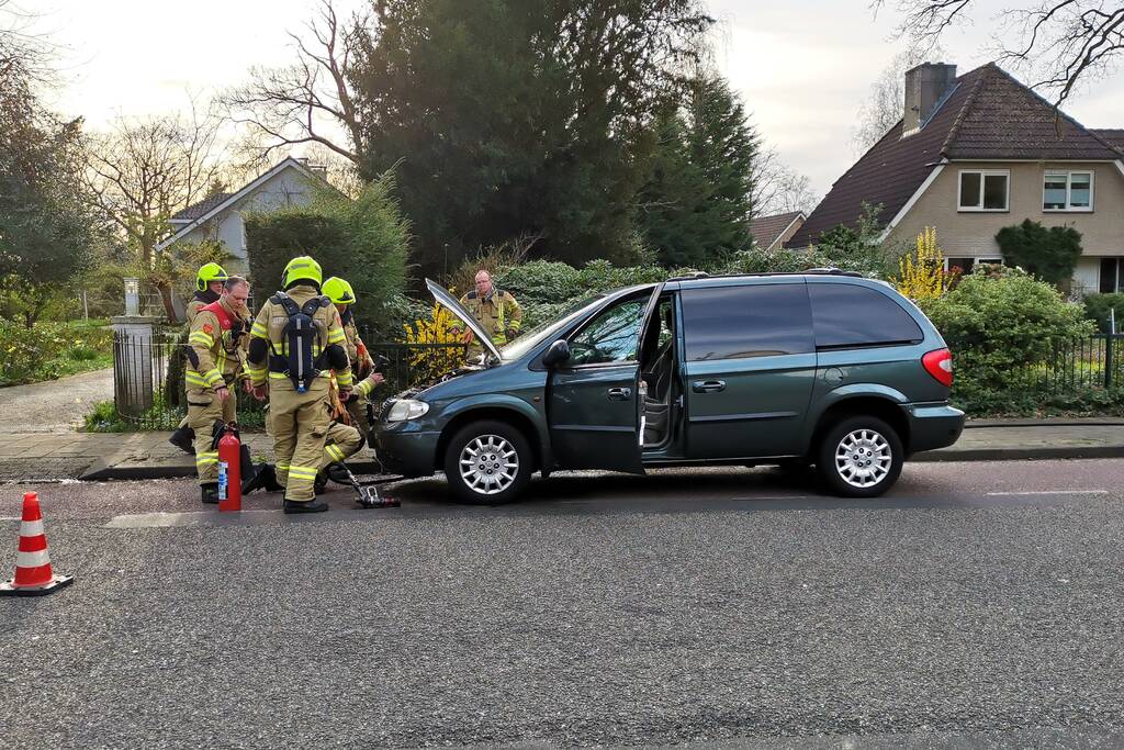 Rook onder de motorkap van de auto