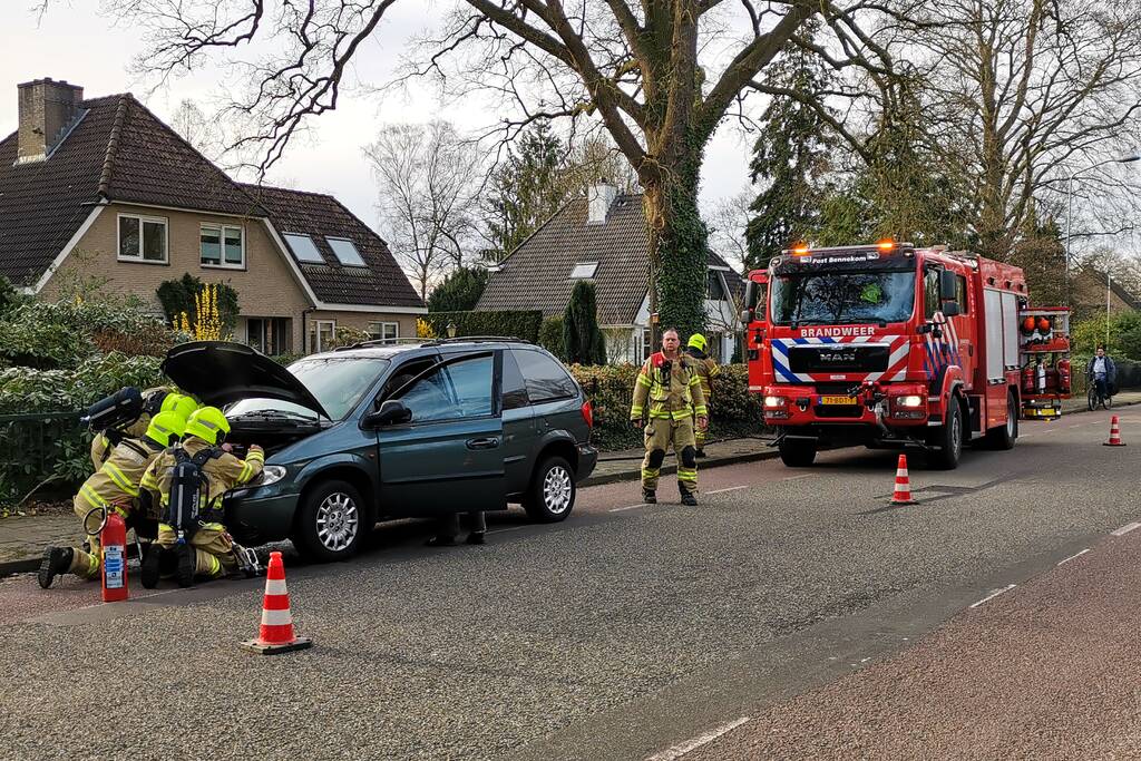 Rook onder de motorkap van de auto
