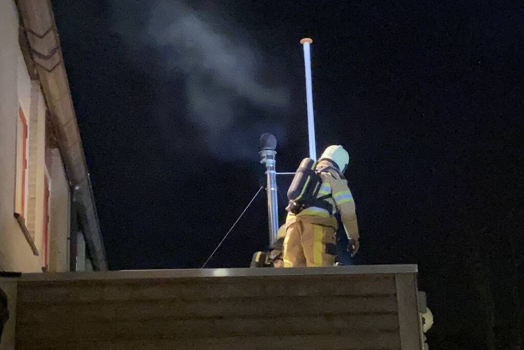 Brand in schoorsteenpijp van palletkachel achter woning